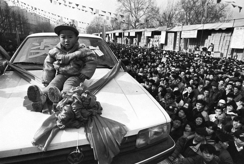1997年，北京街頭的彩票開獎現(xiàn)場，四川來京務工人員伍富貞家3歲的孩子中得一輛轎車。胡金喜攝影像見證四十年.jpg